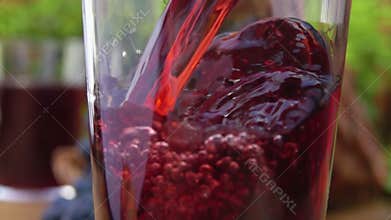 Grape juice is pouring into a glass