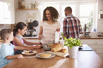 Family At Home Eating Breakfast In Kitchen Together