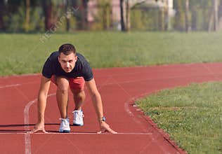 Man on track starting to run. Healthy fitness concept with active lifestyle.