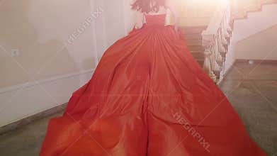 The girl in red dress running up the stairs.