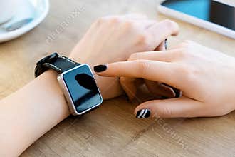 Girl wearing watch, cup of coffee on table
