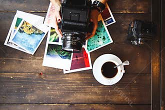 Top view of women`s hands holding printed photos