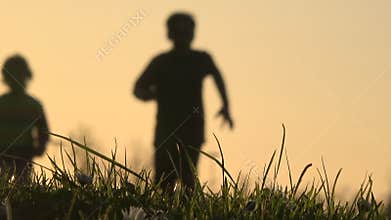 Blurry silhouette of kids running at sunset