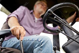 Senior man driving tractor at farm