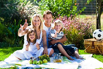 Happy family having a picnic with thumbs up