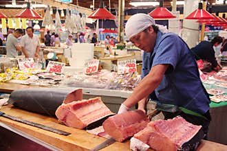 Trader cutting and filetting swordfish meat in Omi-cho market Kanazawa Japan