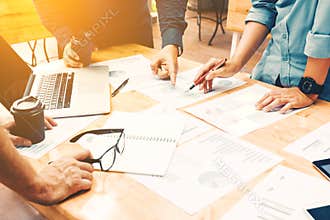 Brainstorming team of asian startup coworkers doing work on desk