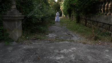 The ghost of the bride wanders through the ruins of the old castle. Bride of the Zombie. 4 k. Slow-motion shooting