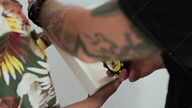 Couple makes measurements of picture in frame