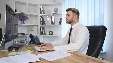 An angry businessman punches his computer after getting upset