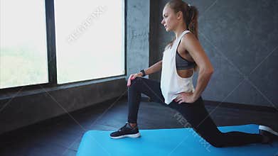 Young woman doing stretching hamstring on yoga mat in fitness club