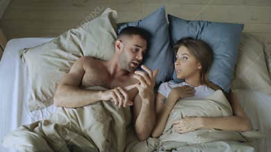 Young beautiful and loving couple chatting and have fun in bed