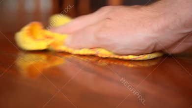 Man dusting wooden table