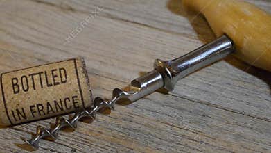 Vintage old corkscrew and rolling wine cork with inscription bottled in France