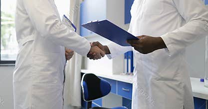 Two male scientists handshake meeting in laboratory scientific specialists shaking hands