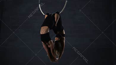 Two beautiful gymnasts performs trick at the aerial hoop