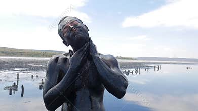 Young Man Making Face Mask with Black Medical Mud at the Lake of Salt Water. Salty Black Dirt Is Good For People With