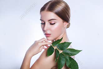 Organic cosmetic . Beautiful woman face portrait with green leaf , concept for skin care or organic cosmetics