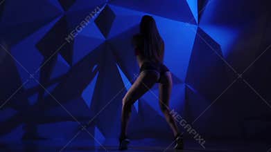 Dance booty in the performance of girl in shorts on a blue graphic background. Slow motion