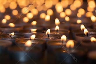 Lighted candle amongst many flaming tea light candles. Beautiful