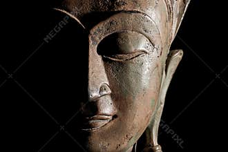 Buddha head. Modern buddhism in focus. Bronze statue face in close up.