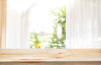 Empty of wood table top on blur of curtain window and garden