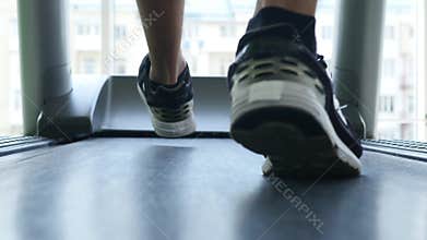 Closeup of athlete`s feet running on treadmill