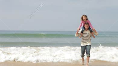 Father And Daughter Playing On Beach