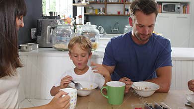 Family Eating Breakfast In Kitchen Together