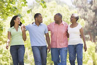 Two couples walking outdoors arm in arm smiling
