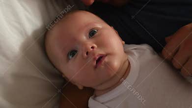 Parents Lying In Bed Cuddling Baby Daughter