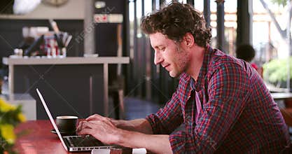 Mature Man In Cafe Working On Laptop