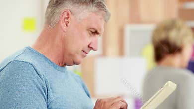 Happy casual businessman using tablet