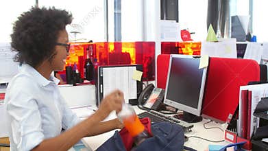 Businesswoman Arriving In Office And Sitting At Desk