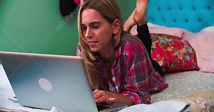Woman Lying On Bed At Home Making Video Call On Laptop