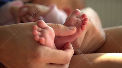 Mom hands foot massage newborn baby