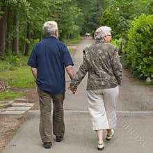 Elderly couple walking hand in hand