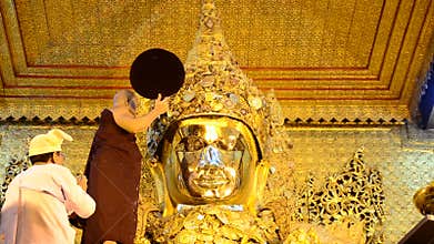 Ritual commences monks wash the face and brush the teeth of the Buddha image