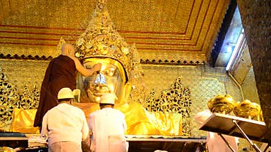 Ritual commences monks wash the face and brush the teeth of the Buddha image