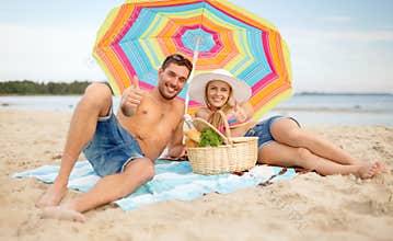 Couple having picnic and sunbathing on beach