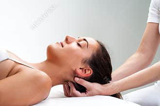 Physiotherapist pressing back of woman's head.
