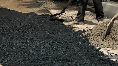 Workers Stack Asphalt on the Road