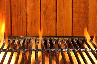 Empty BBQ Flaming Grill And Wood Wall In The Background