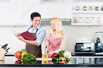 Asian couple sitting on floor reading books
