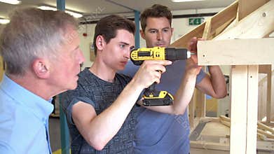 Teacher Helping College Student Studying Carpentry