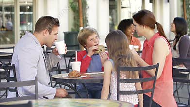 Family Enjoying Snack At Outdoor Cafï¿½