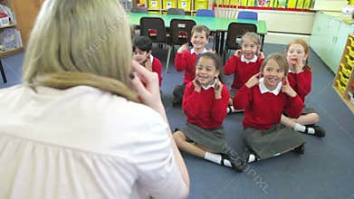 Pupils Copying Teacher's Actions Whilst Singing Song