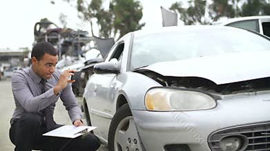 Loss Adjuster Inspecting Car Involved In Accident