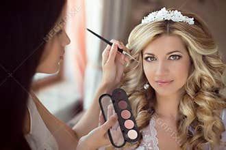 Professional Stylist makes makeup bride on the wedding day. Beau
