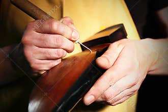 Shoemaker sews shoes